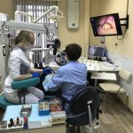 endodontist treats teeth under a microscope